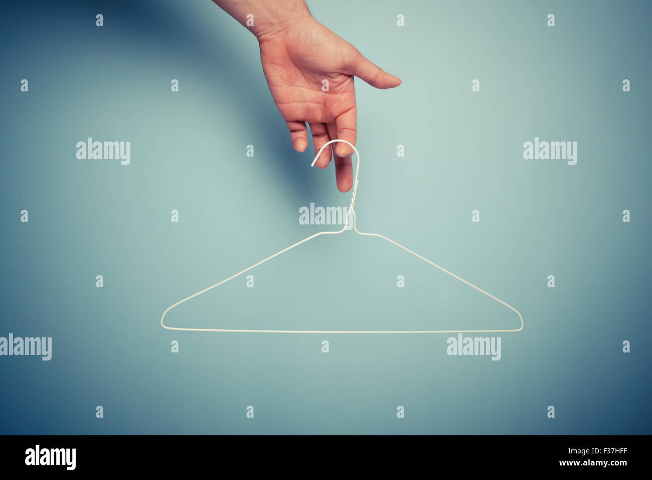 A Hand is holding a wire hanger Stock Photo