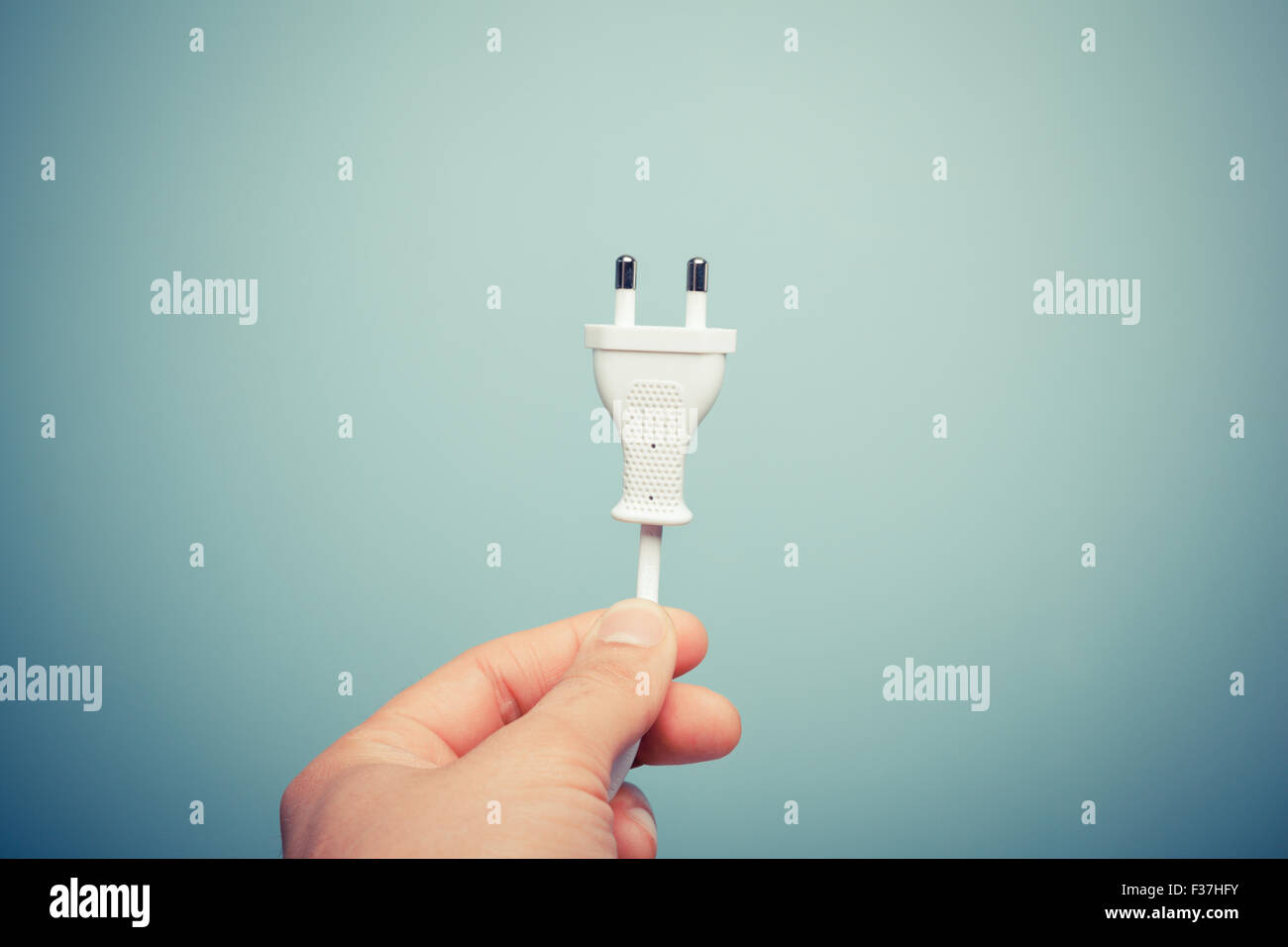 A hand is holding an electric plug Stock Photo