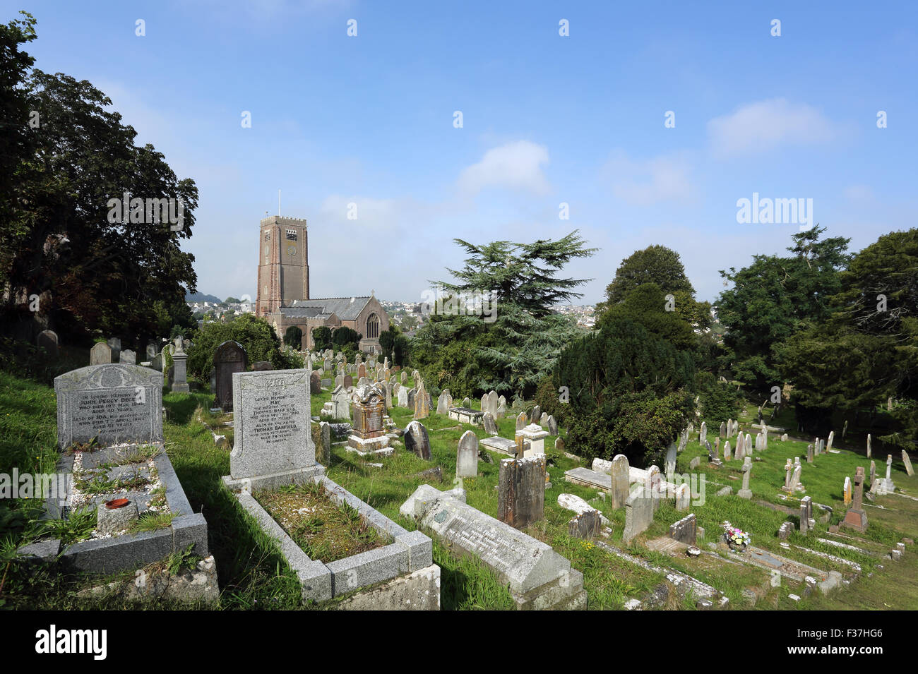 Graveyard in grounds of St. Mary's Church, Brixham, Devon, England, UK, with the church in the background. Stock Photo