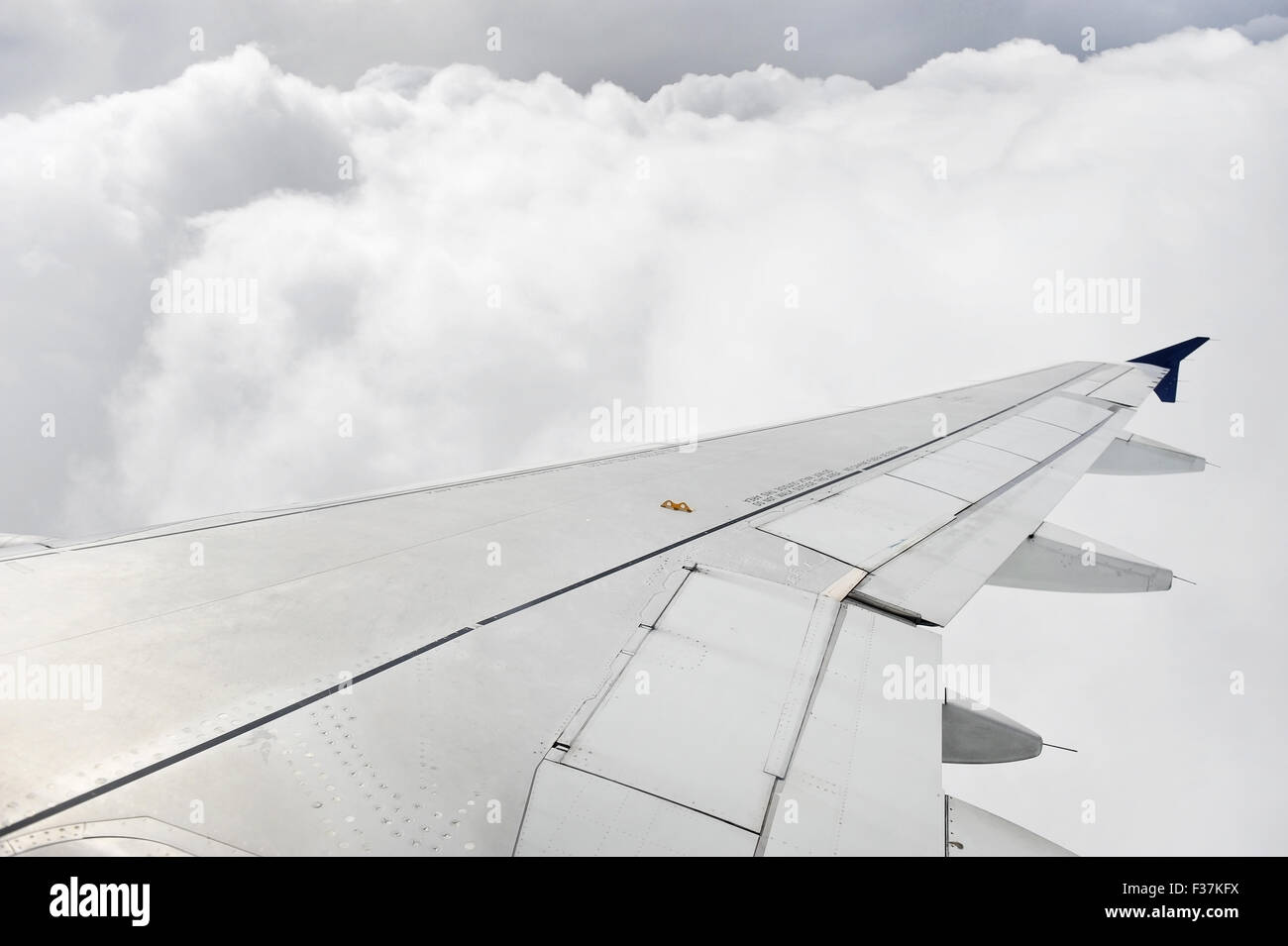 Shot taken through a window with an airplane wing and stormy clouds in background Stock Photo