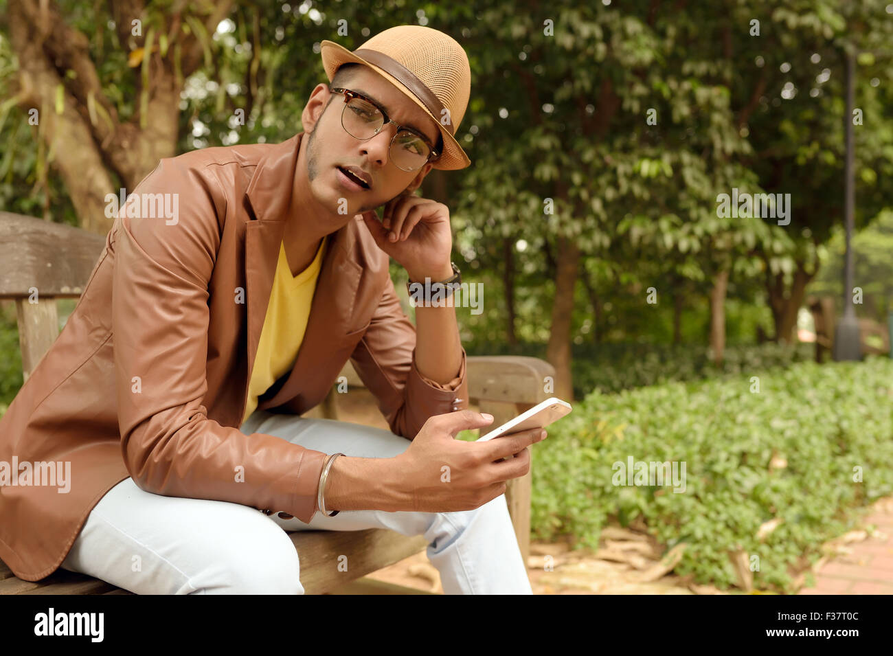 Asian , Man , Indian Ethnicities , Smart Phone , Casual Clothing , Outdoor . Stock Photo