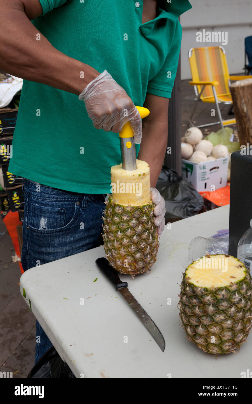 Man coring a pineapple USA Stock Photo Alamy