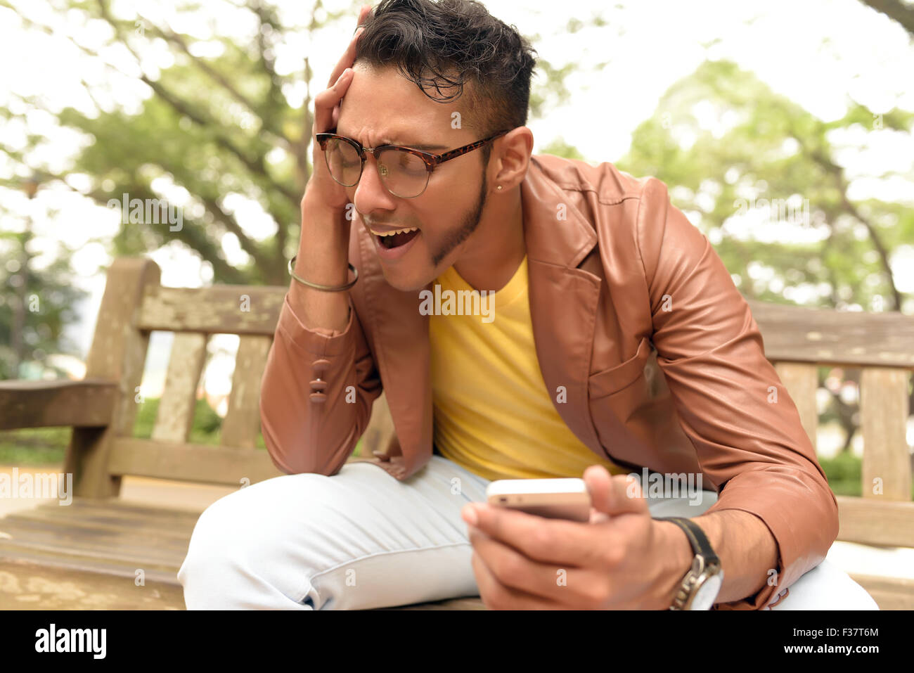 Asian , Man , Indian Ethnicities , Smart Phone , Casual Clothing , Outdoor . Stock Photo