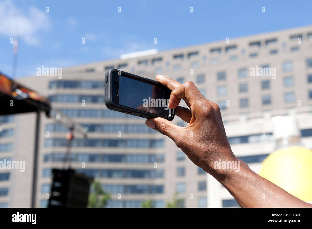 Man video taping an outdoor event with mobile phone - USA Stock Photo