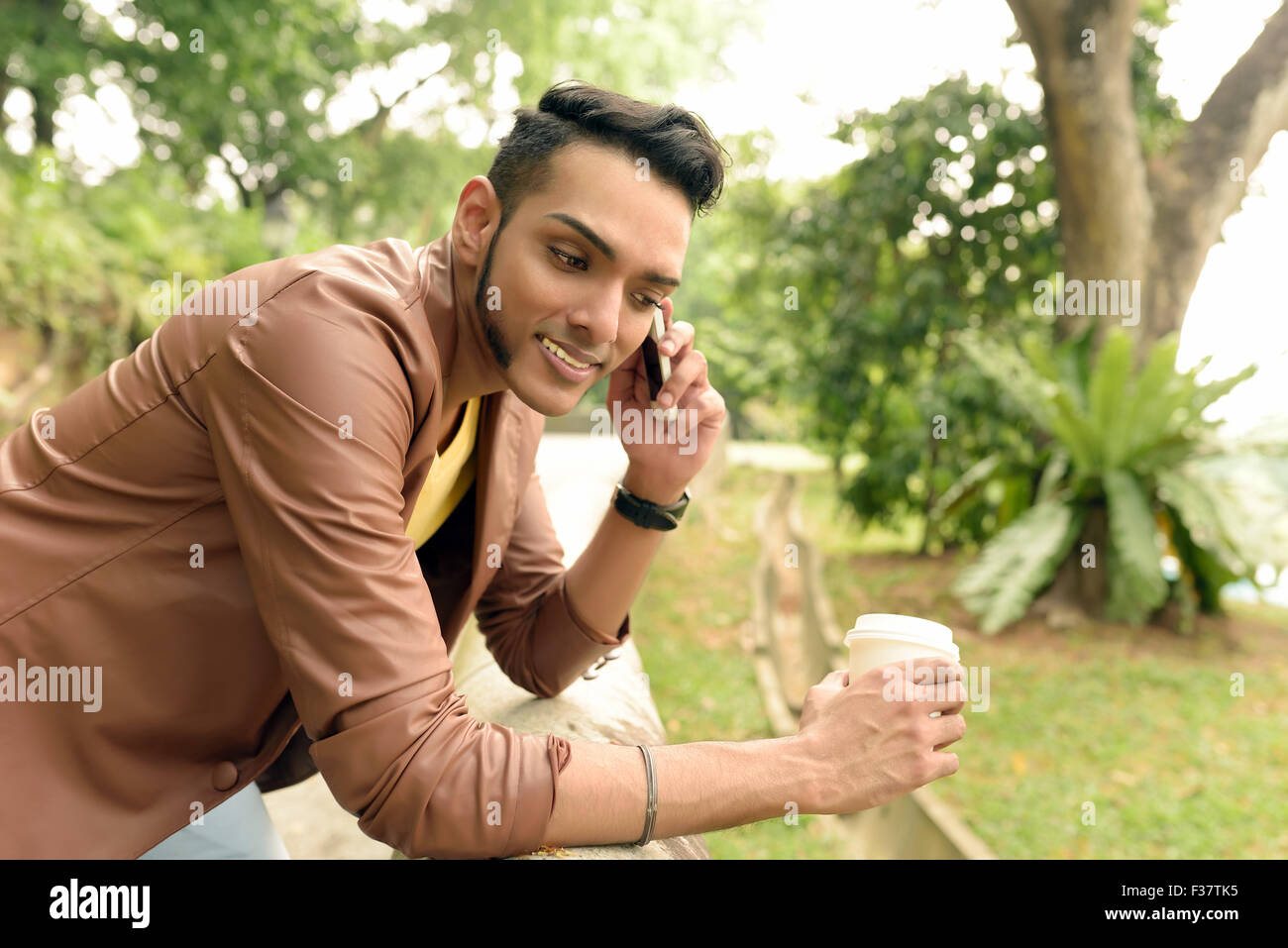 Asian , Man , Indian Ethnicities , Smart Phone , Casual Clothing , Outdoor . Stock Photo