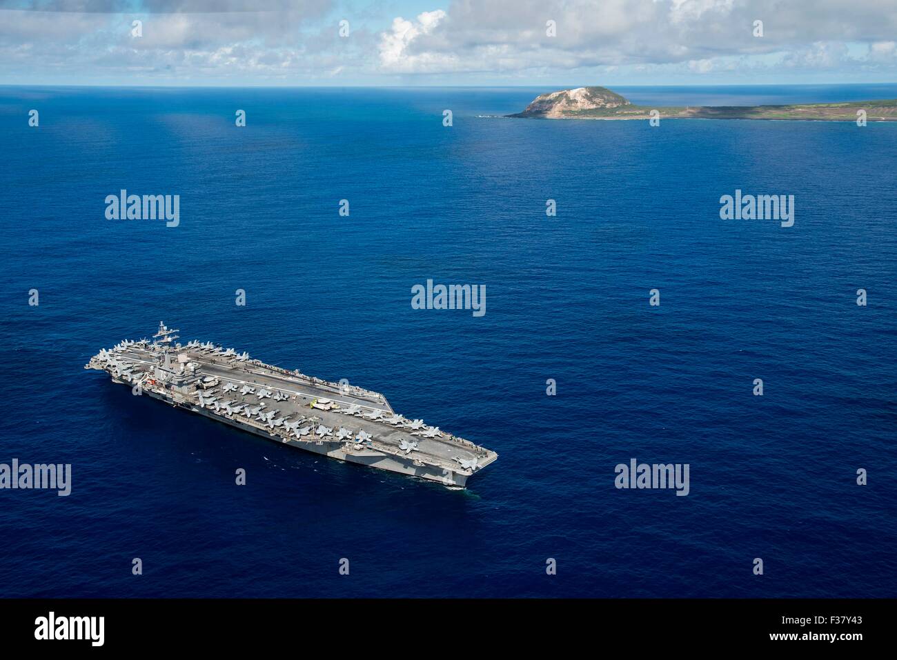 US Navy Nimitz-class nuclear aircraft carrier USS Ronald Reagan pauses to honor fallen service members from  the Battle of Iwo Jima while underway off the island of Iwo To, formerly known as Iwo Jima September 29, 2015 in the Pacific Ocean.  This year marks the 70th anniversary of the end of World War II. Stock Photo