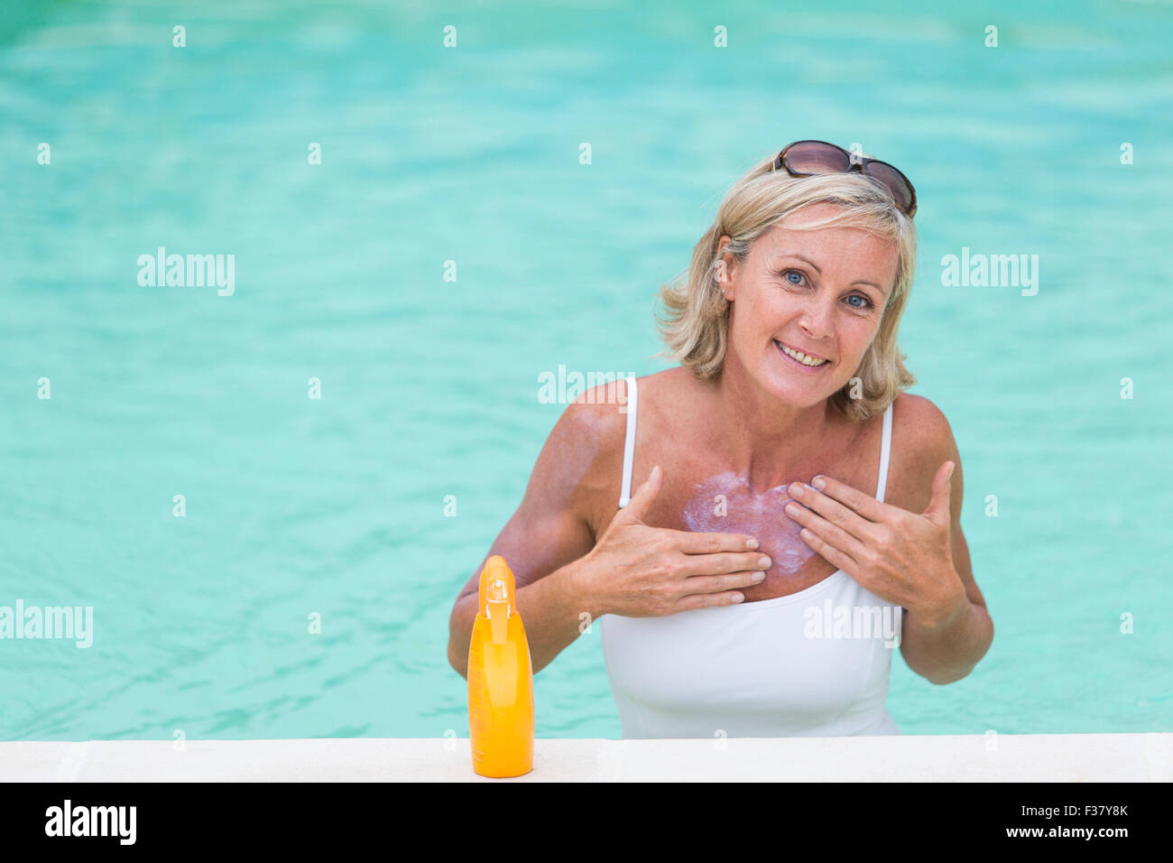 Woman applying sunblock at the beach. Stock Photo