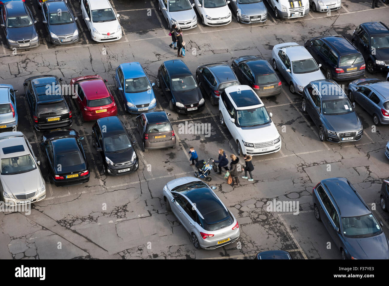 High view from Clifford's Tower - people walking, cars driving, manoeuvring or parked, in a busy, crowded Castle car park, York, North Yorkshire, UK. Stock Photo
