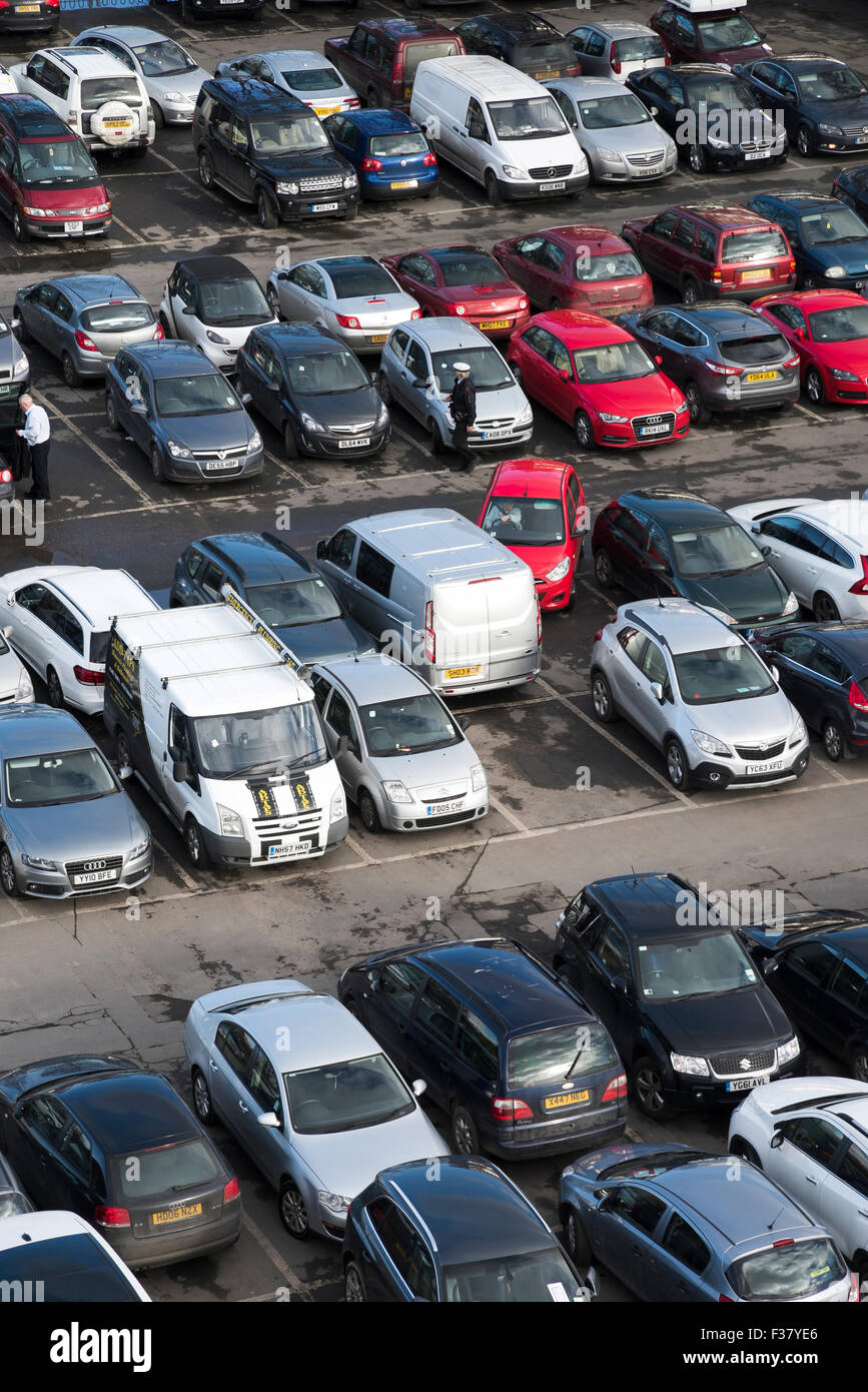 High view from Cliffords Tower - warden on patrol, cars driving, manoeuvring or parked, in a busy, crowded Castle car park, York, North Yorkshire, UK. Stock Photo