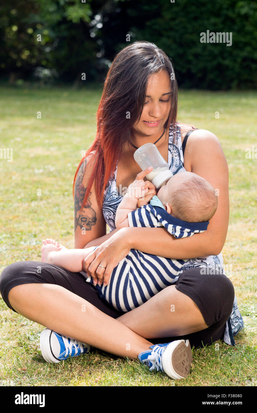 mother feeding baby with milk from a bottle Stock Photo