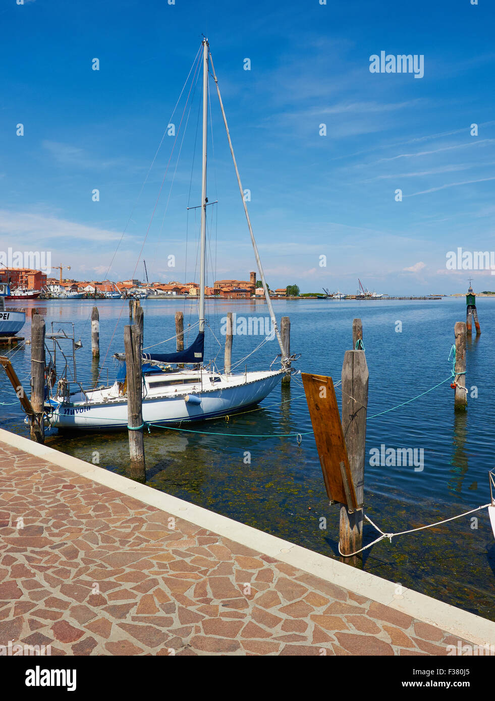 Yacht moored amongst wooden mooring posts on Chioggia island Venetian Lagoon Veneto Italy Europe Stock Photo