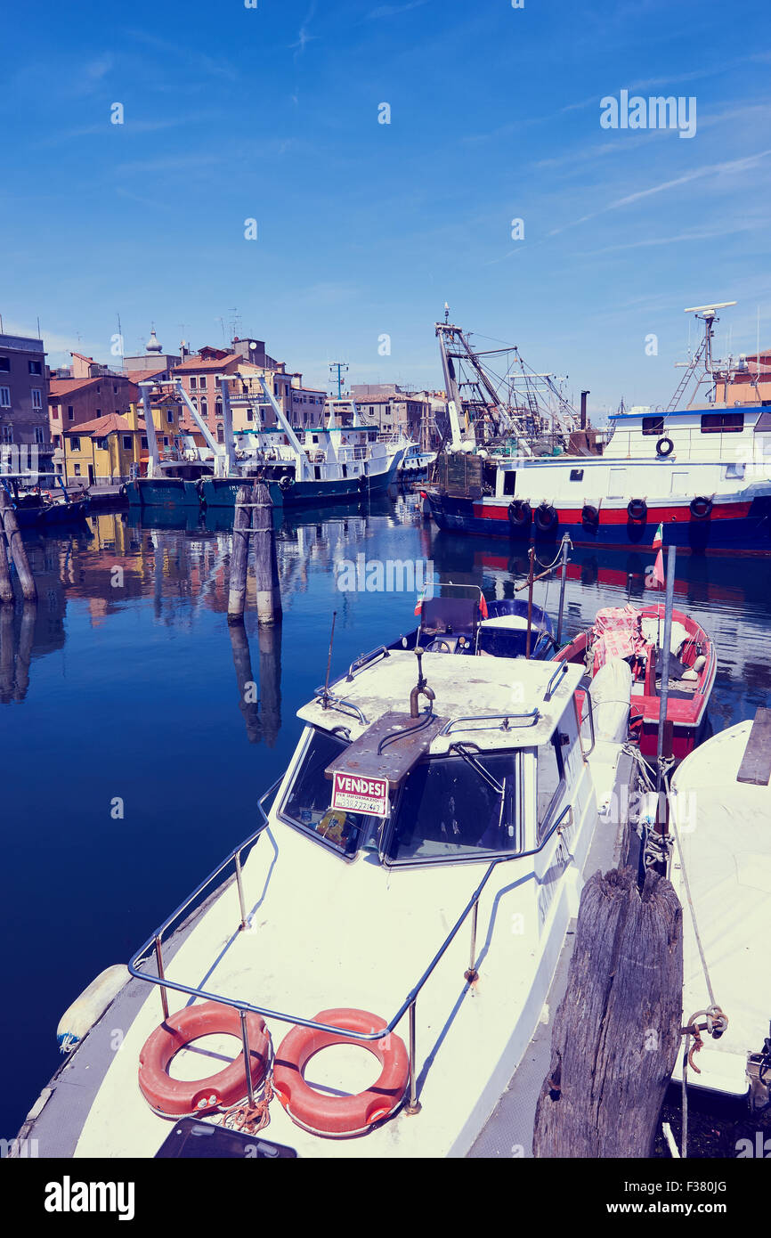Boat for sale (vendesi) with fishing trawlers moored in harbour Chioggia Veneto Italy Europe Stock Photo