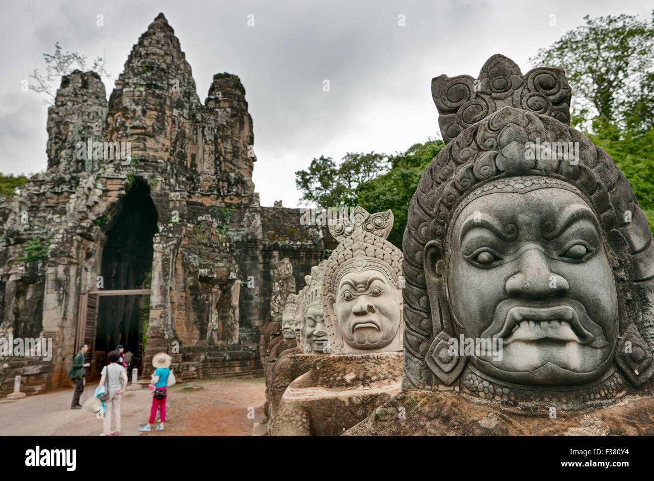 Giant carved stone faces at the South Gate of the Angkor Thom. Angkor Archaeological Park, Siem Reap Province, Cambodia. Stock Photo