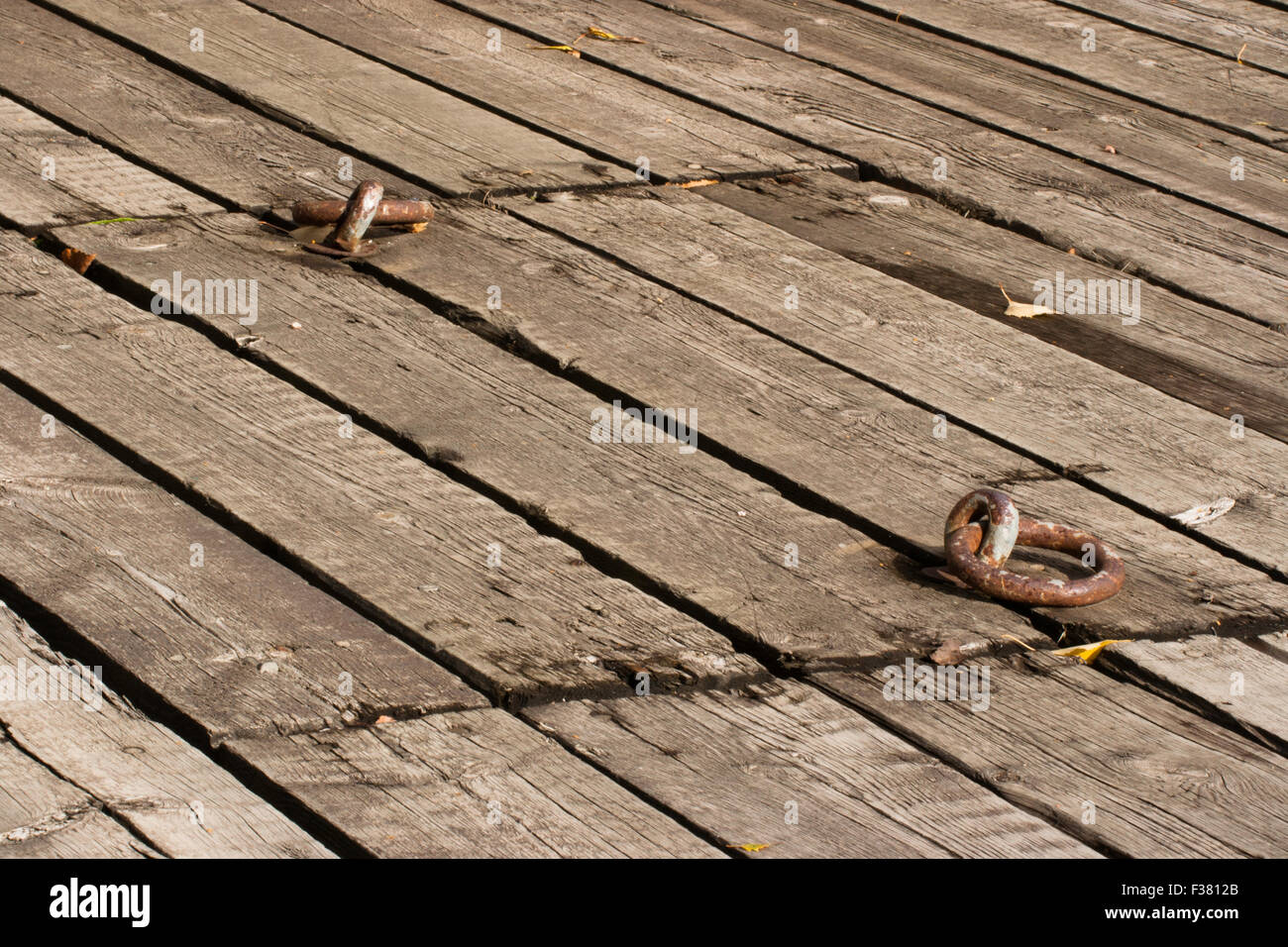 Old wooden deck and a hatch with two rusty metal handles Stock Photo
