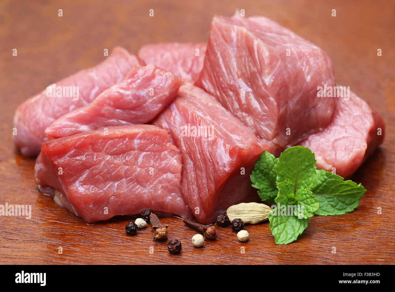 Raw beef with spices on wooden surface Stock Photo