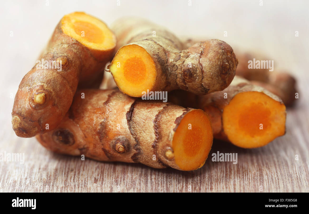 Raw turmeric on wooden surface Stock Photo - Alamy
