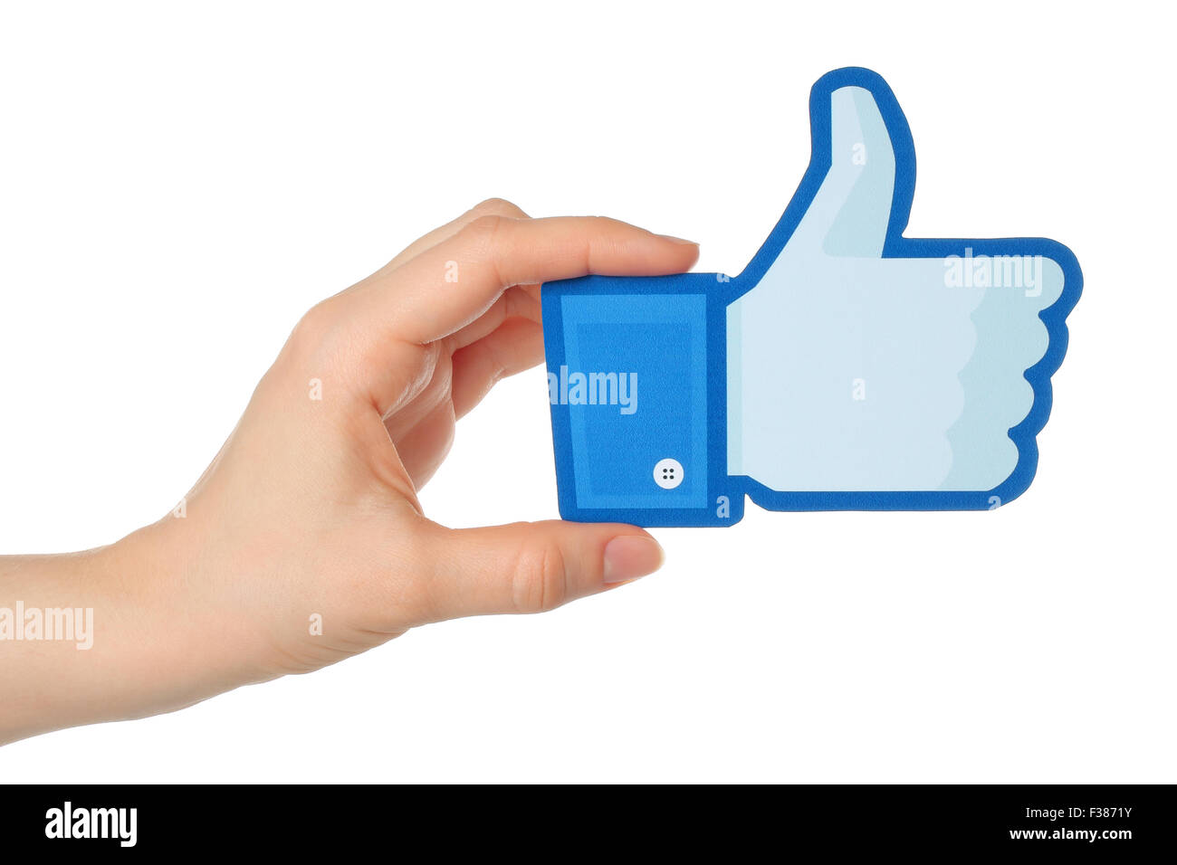 KIEV, UKRAINE - JANUARY 24, 2015: Hand holds facebook thumbs up sign printed on paper on white background. Stock Photo