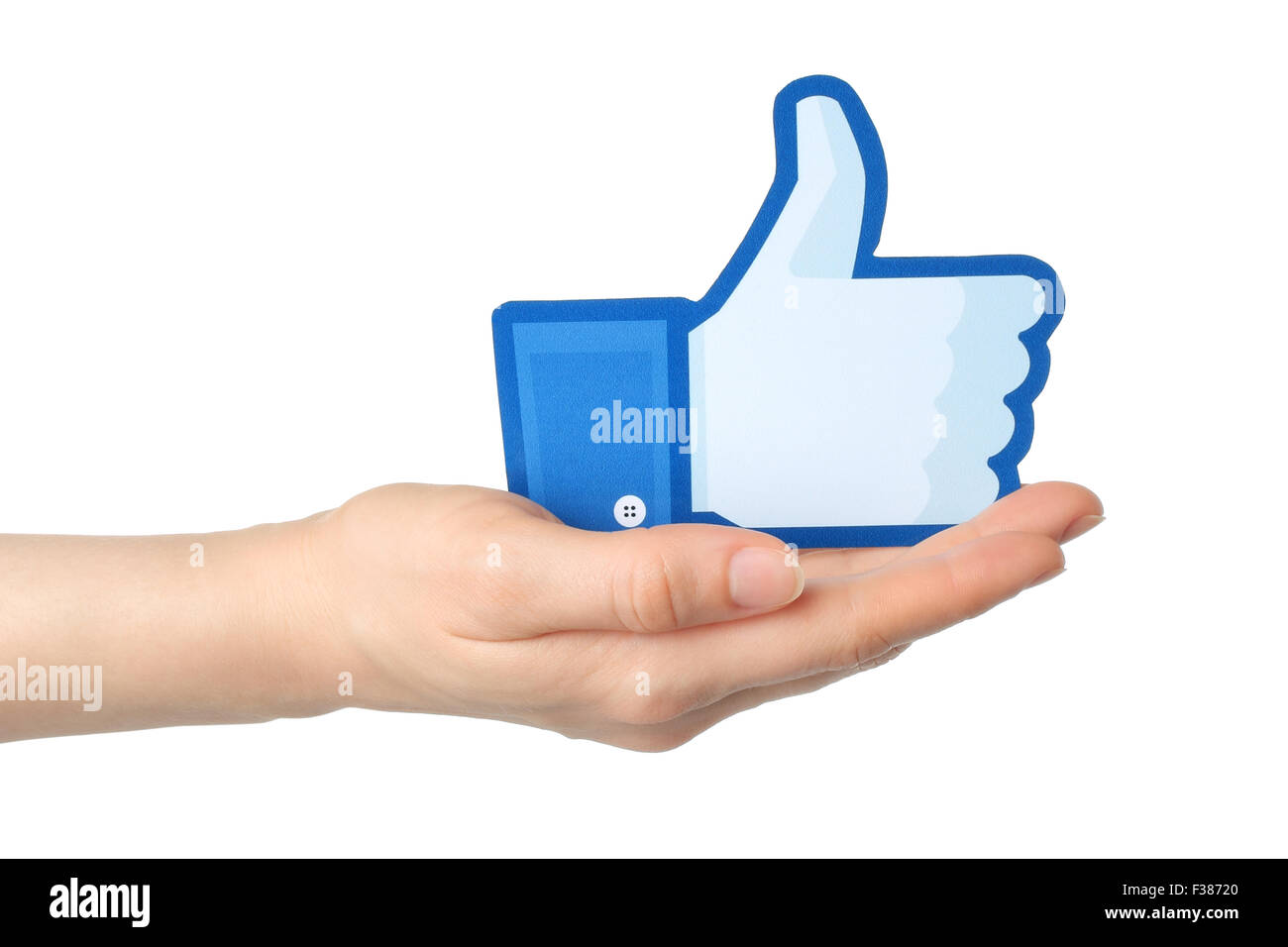 KIEV, UKRAINE - JANUARY 24, 2015: Hand holds facebook thumbs up sign printed on paper on white background. Stock Photo