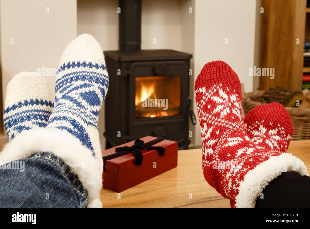 Couple relaxing in Christmas socks in front of cozy fire Stock Photo