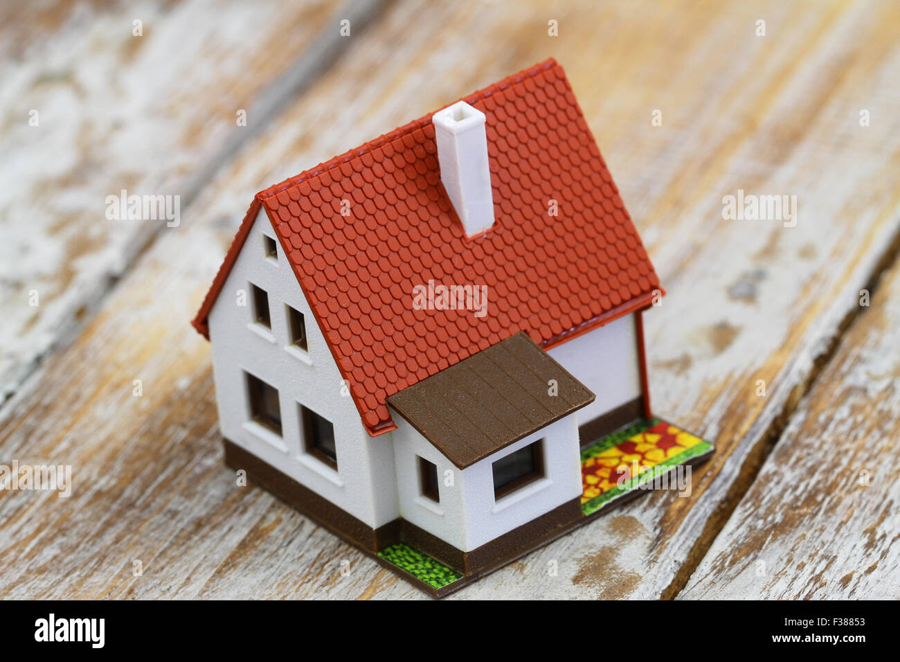 Model house on rustic wooden surface, closeup Stock Photo