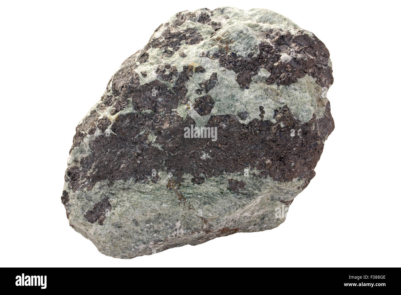 Tremolite-magnetite rock (iron ore). Light green is amphibole group mineral tremolite. Dark is iron oxide magnetite. Stock Photo