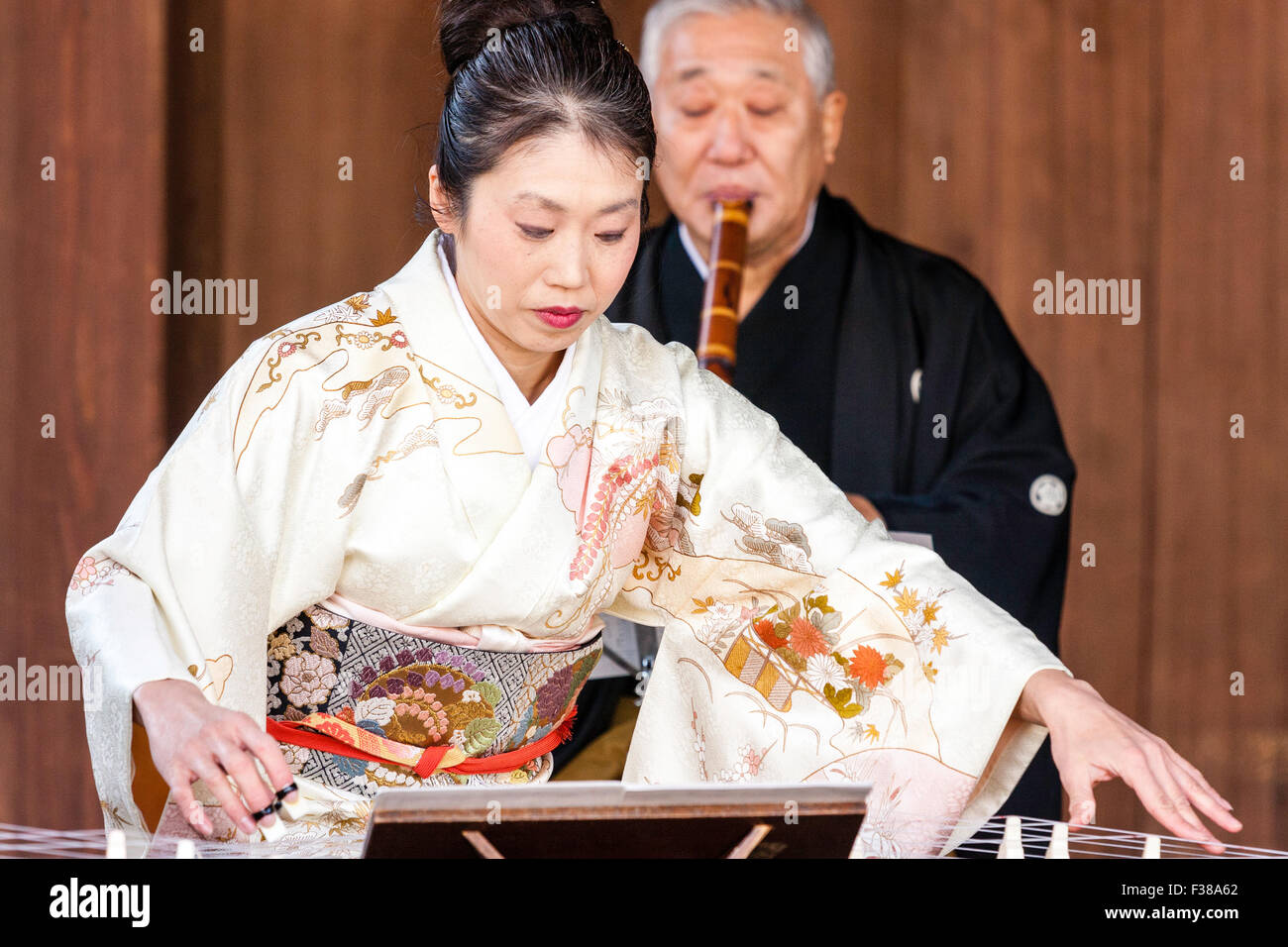 Kyoto, Yasaka Shinto shrine, Noh performance. Mature Japanese woman in  kimono, kneeling, playing the koto, sokyoku, with man behind playing the  flute Stock Photo - Alamy
