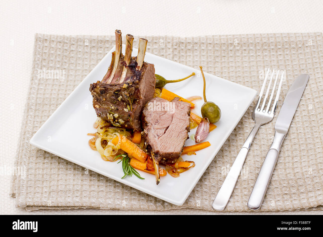 Grilled rack of lamb with carrot onion, garlic and capers Stock Photo