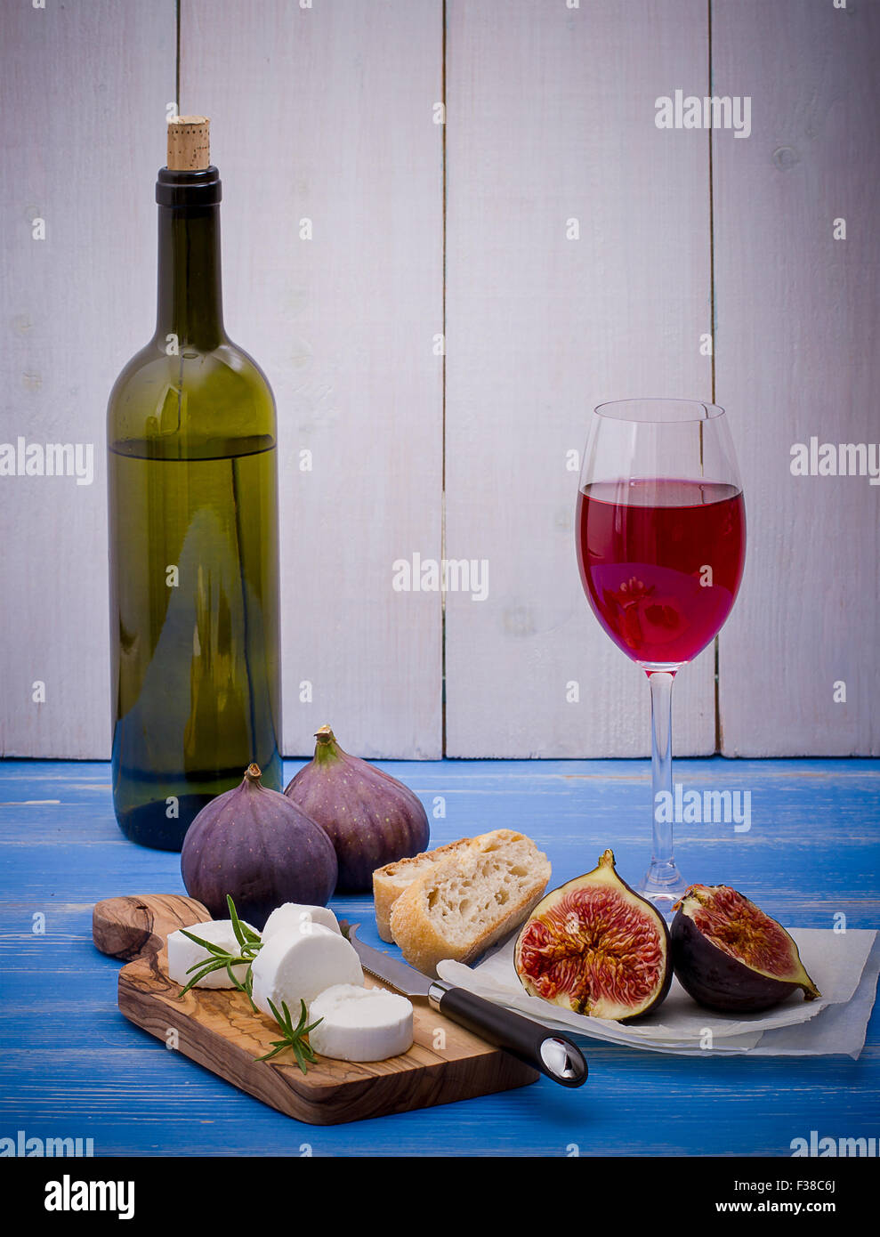 Goat cheese with ripe figs and wine on blue background Stock Photo