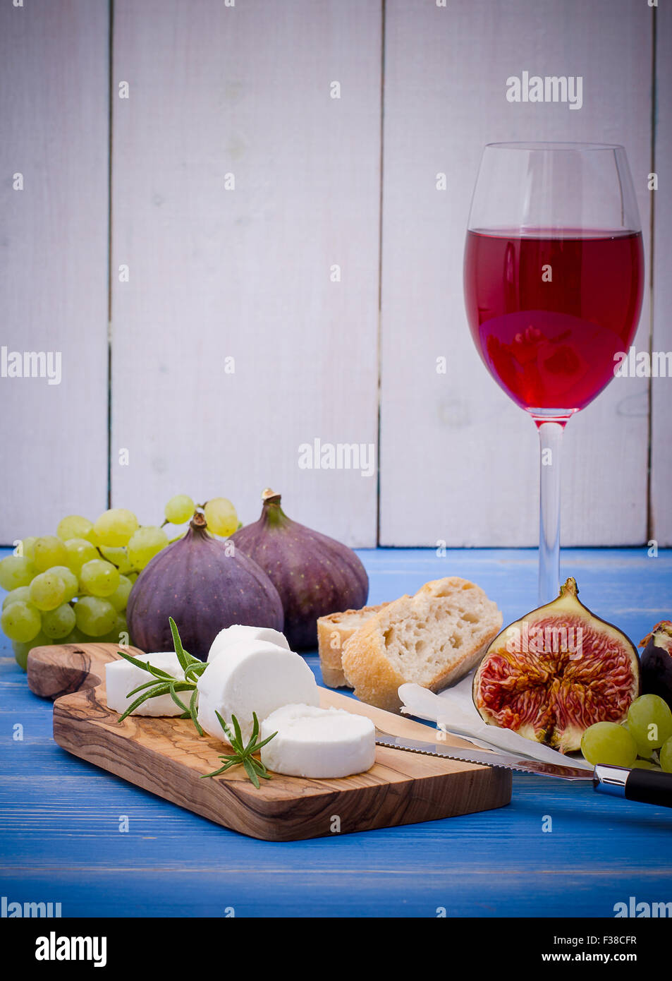 Feta cheese with ripe figs and wine on blue, horizontal Stock Photo