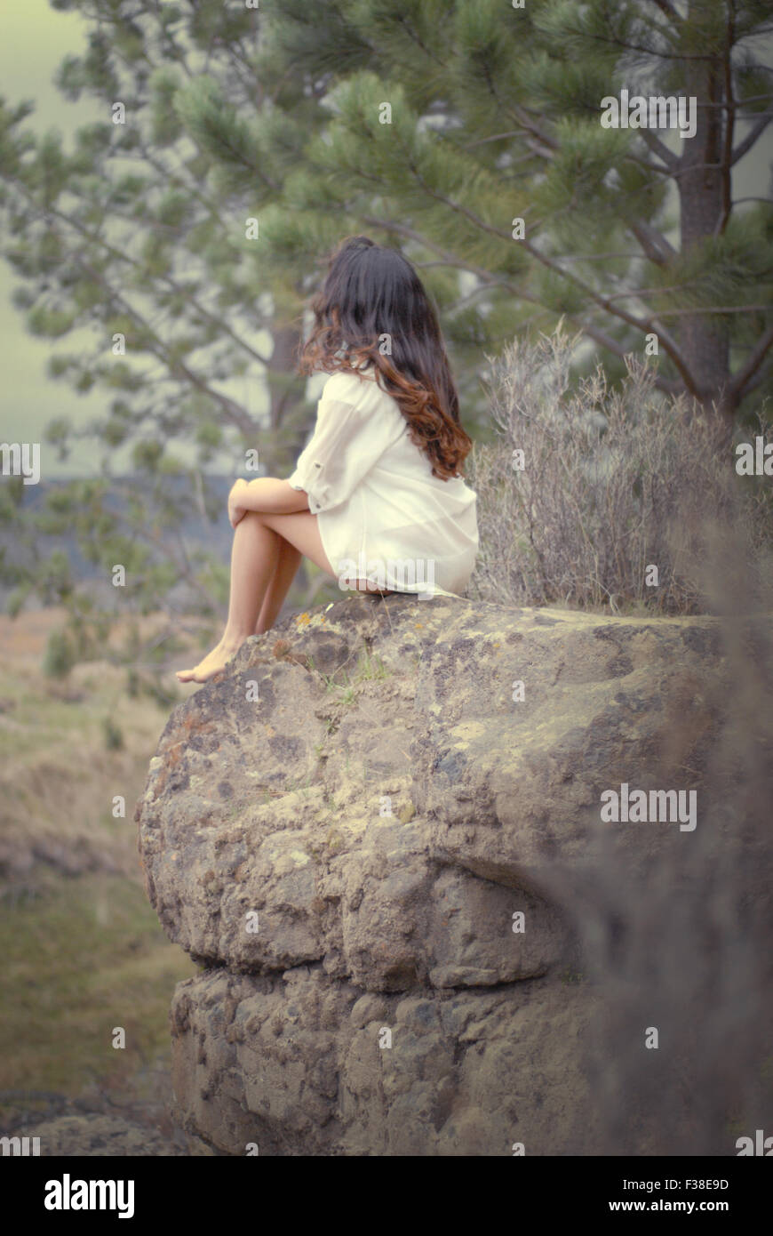 cute girl sitting in a big stone in the forest Stock Photo - Alamy