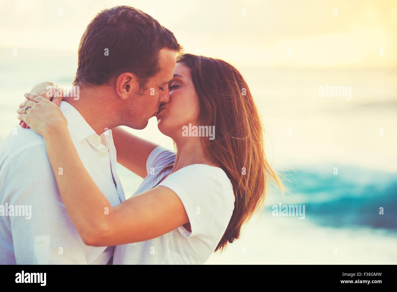 Romantic Happy Young Couple Kissing on the Beach at Sunset Stock ...