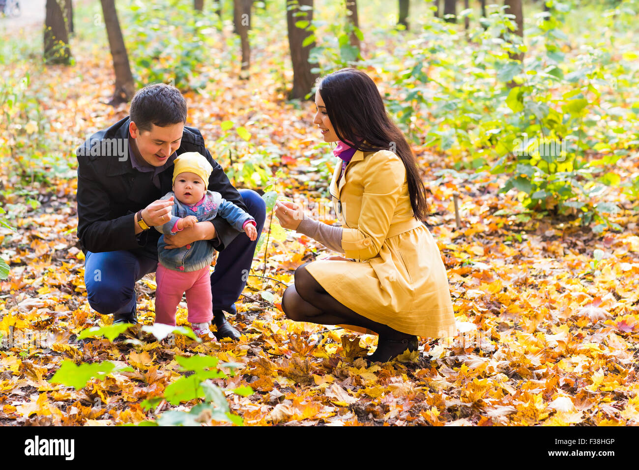 Young family for a walk in the autumn park with baby Stock Photo - Alamy
