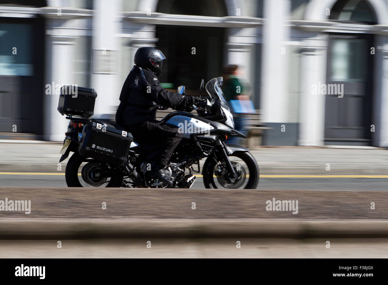 A blurred moving Suzuki motorbike at speed motion blur on 'The Strand' at Liverpool One, Liverpool, Merseyside, UK Stock Photo