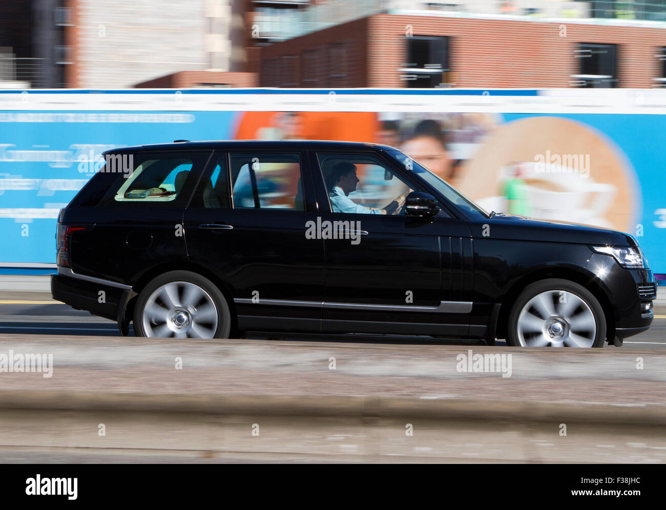 A blurred moving Range Rover Vogue at speed motion blur on 'The Strand' at Liverpool One, Liverpool, Merseyside, UK Stock Photo