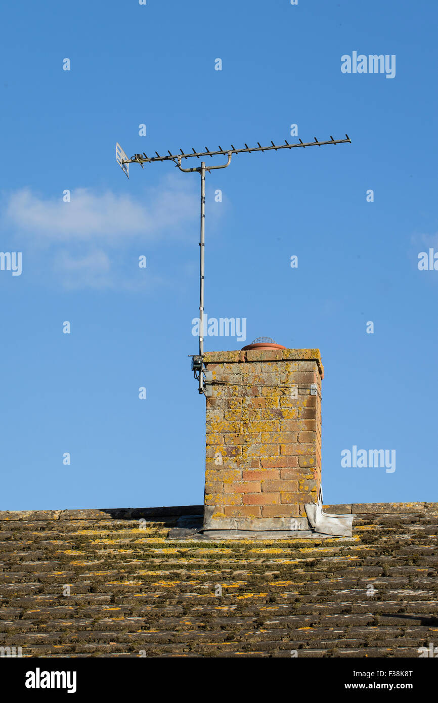 Suburban house rooftop showing TV aerial attached to the chimney stack