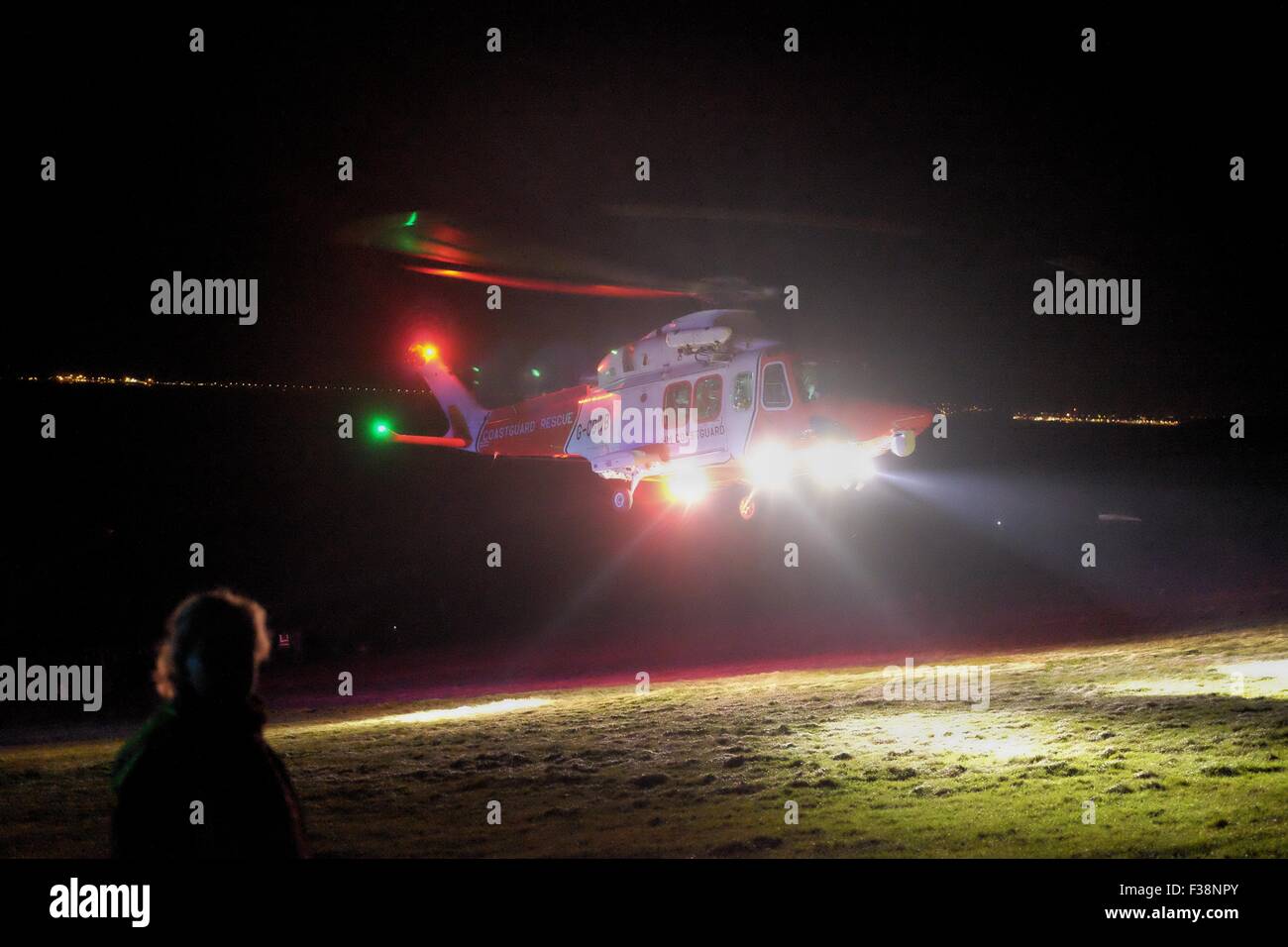 Durdle Door, Dorset, UK. 1 October 2015. A  Coastguard Helicopter was called on to airlift a man who had had a heart attack following an event on the Jurassic Coast.  The man, who had been a spectator at the  'Night of Heritage Light' where the famous landmark  Durdle Door was lit up to celebrate the International Year of Light, collapsed after climbing up the steep path back to the car park and was treated by emergency staff until the Helicopter arrived to take the man to hospital. Credit:  Tom Corban/Alamy Live News Stock Photo