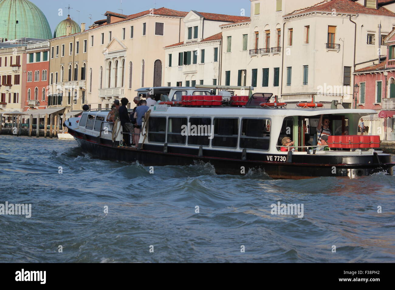 A river taxi transports people through Venice, Italy Stock Photo