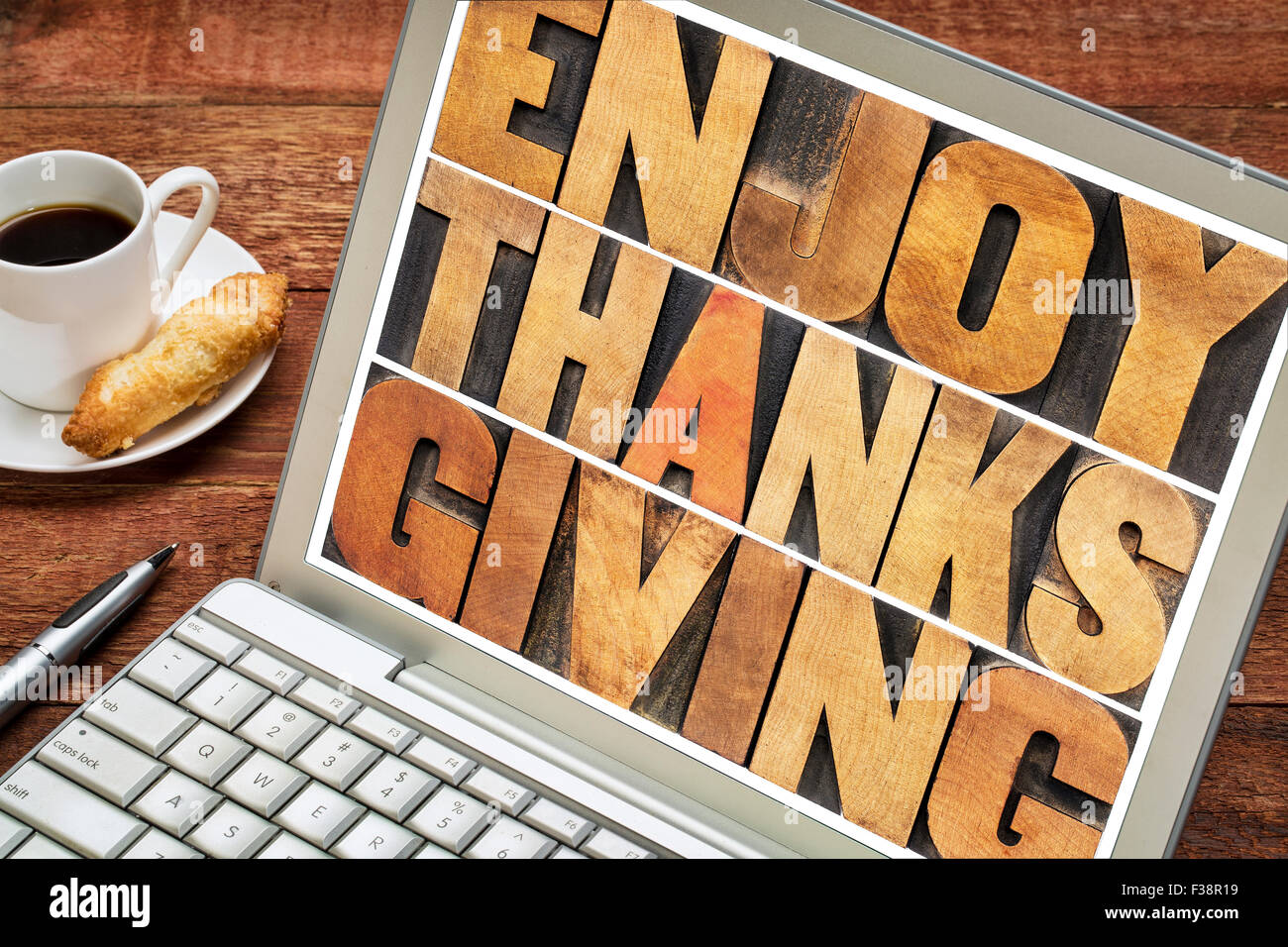 Enjoy  Thanksgiving  - word abstract in vintage letterpress wood type blocks on a laptop screen Stock Photo