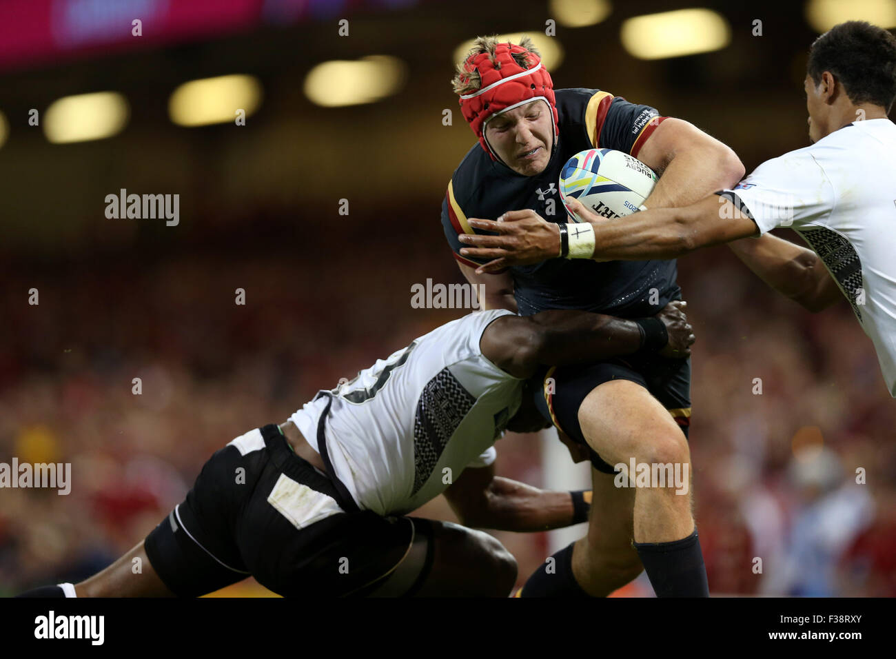 Cardiff, Great Britain. 1st Oct, 2015. Tyler Morgan (C) of Wales is tackled by two players of Fiji during the Rugby World Cup 2015 Pool A match between Wales and Fiji at the Millennium Stadium in Cardiff, Wales, Great Britain, on Oct. 1, 2015. Wales won 23-13. Credit:  Han Yan/Xinhua/Alamy Live News Stock Photo