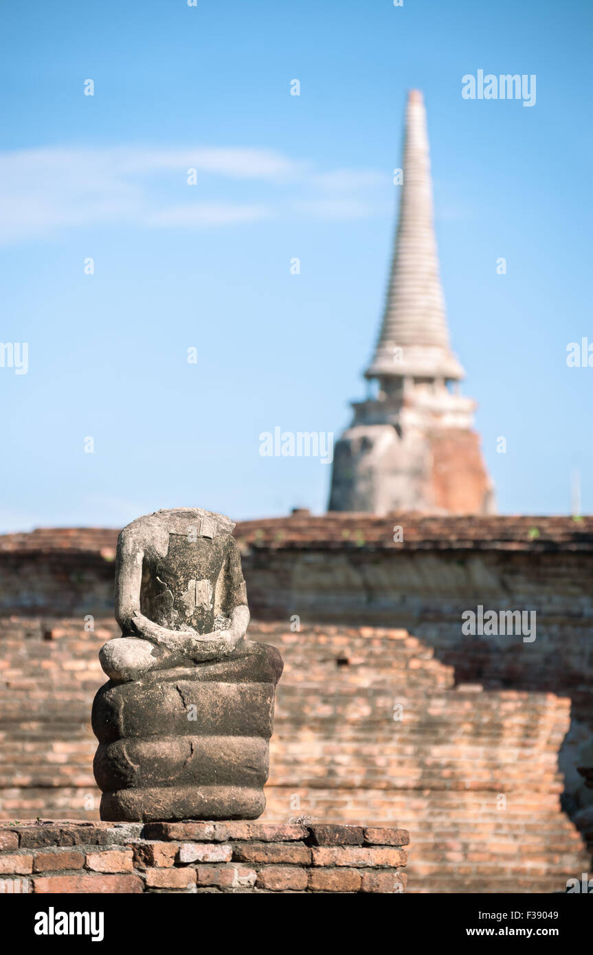 Small Buddha statue and ancient chedi at Wat Mahathat temple, Ayutthaya, Thailand Stock Photo