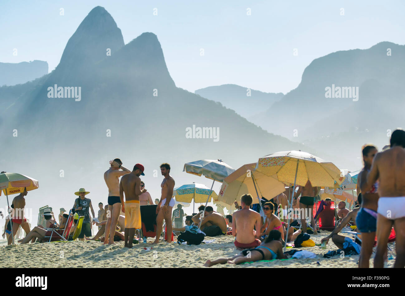 RIO DE JANEIRO, BRAZIL - JANUARY 20, 2013: Locals and visitors crowd Ipanema Beach against the iconic Two Brothers Mountain. Stock Photo