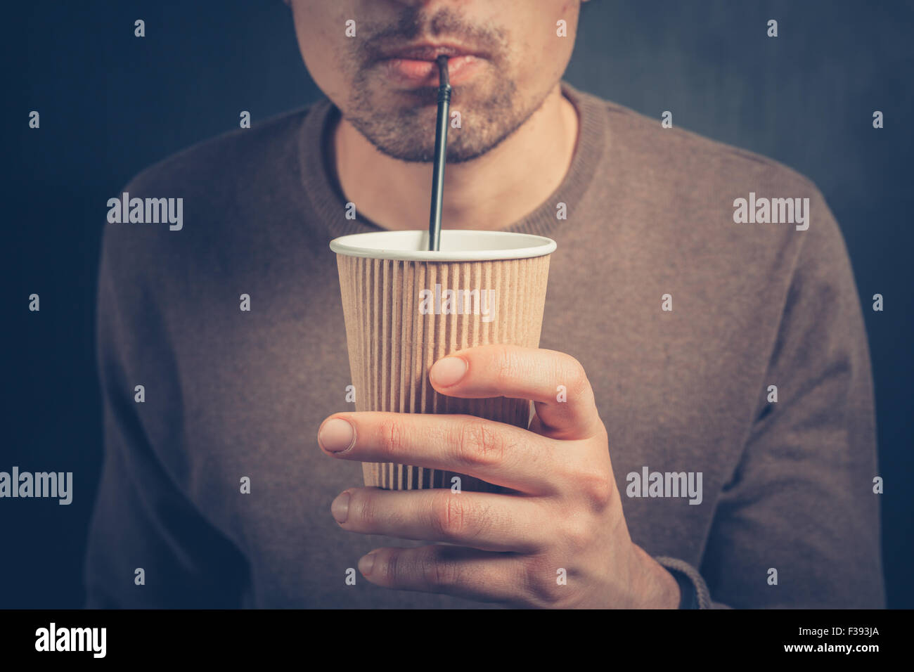 https://c8.alamy.com/comp/F393JA/a-young-man-is-using-a-straw-to-drink-from-a-paper-cup-F393JA.jpg