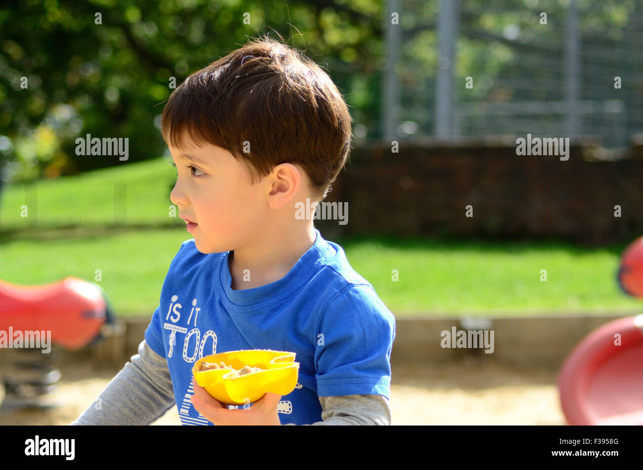 A child plays with the sand in the children's play area in the local park Stock Photo