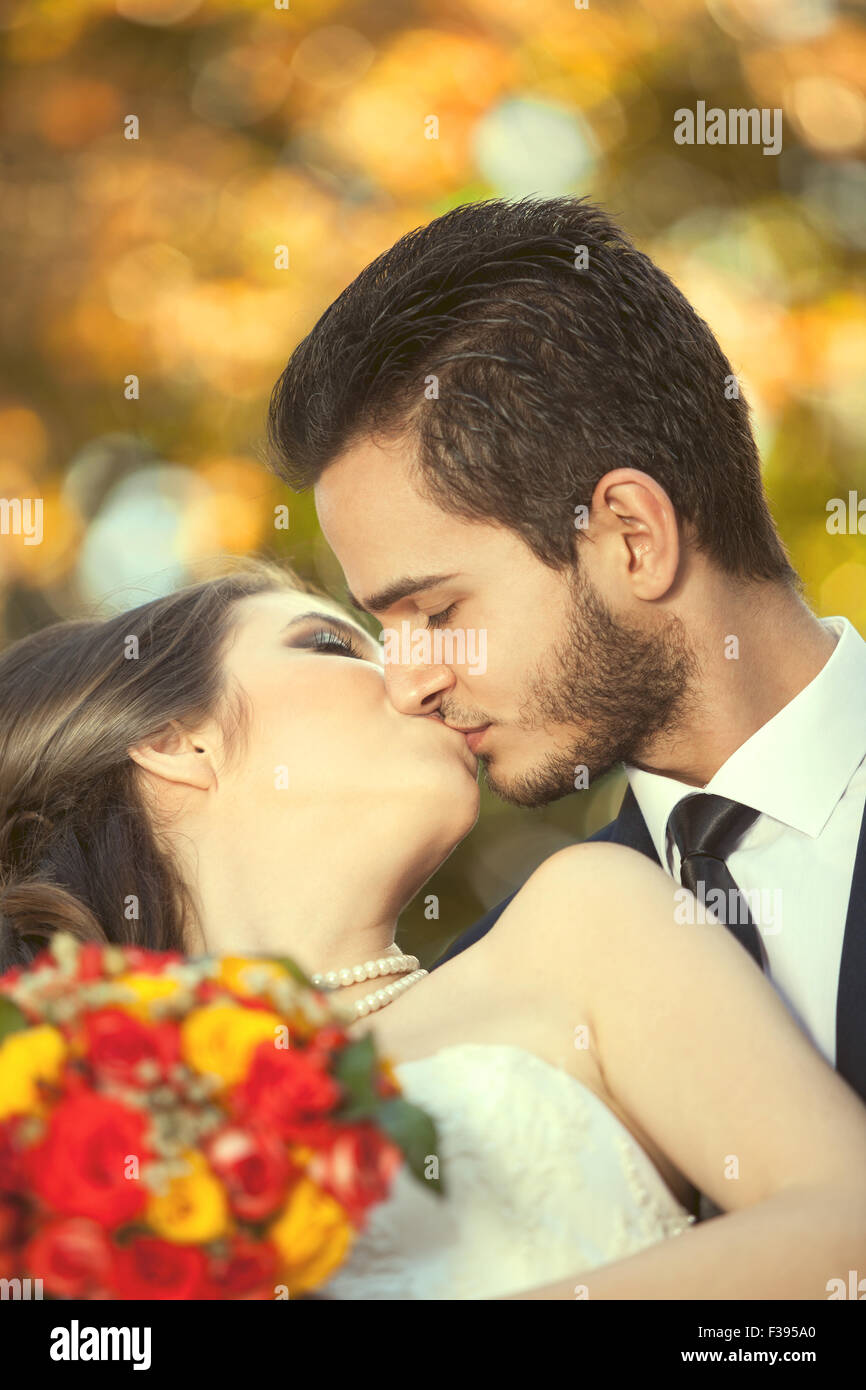 Just married couple kissing on blurred autumn background. Happiness and  joy. Love is in the air. Warm tonning. Autumn Stock Photo - Alamy
