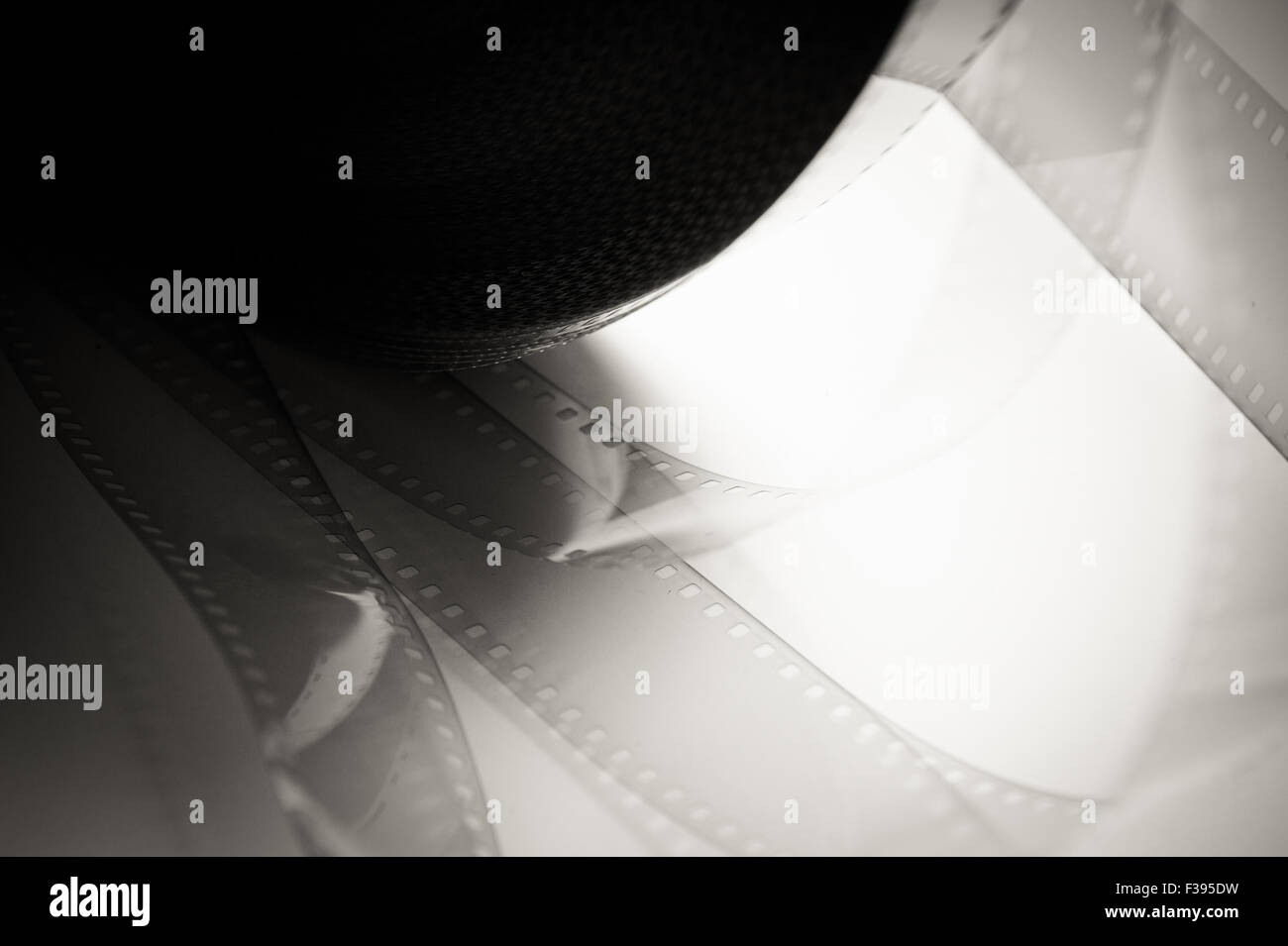 35 mm film detail with movie reel in black and white Stock Photo - Alamy