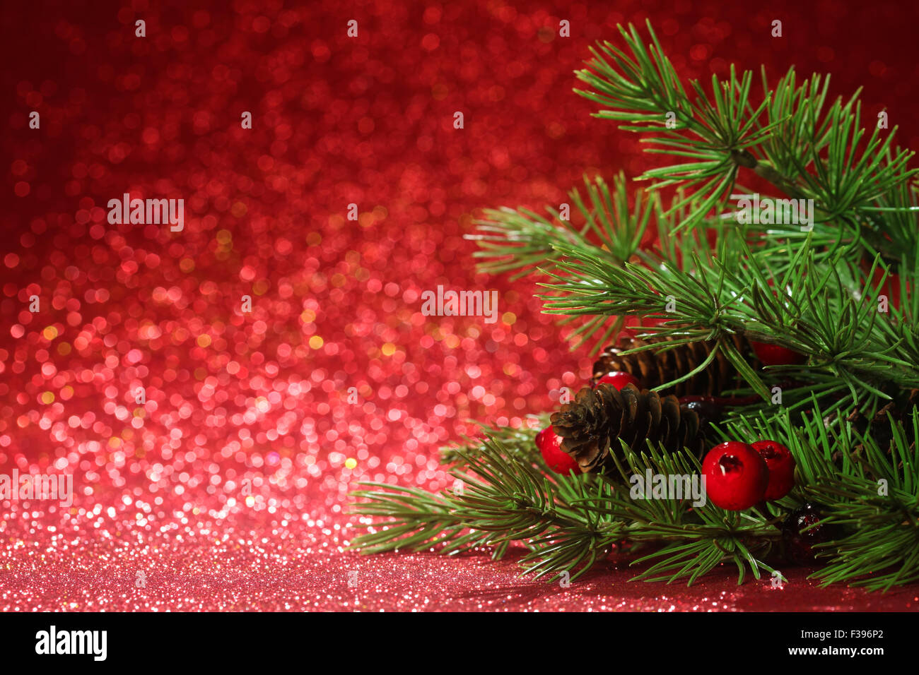 Christmas tree branches on glittering red background Stock Photo - Alamy