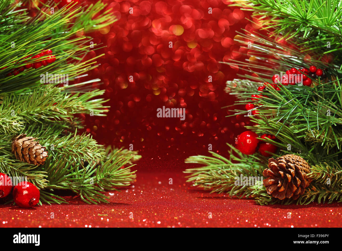 Christmas tree branches on glittering red background Stock Photo