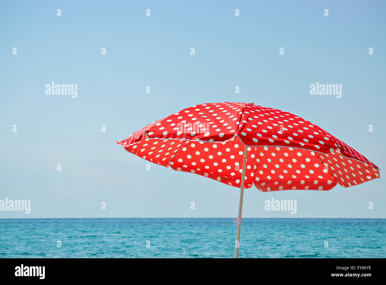 Red parasol on the beach and beautiful turquoise sea Stock Photo