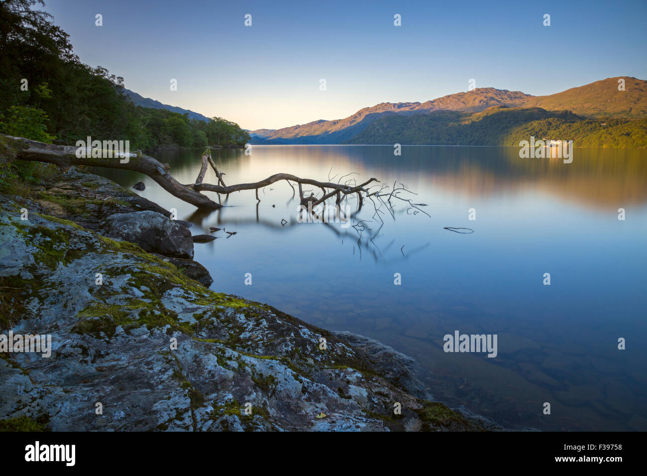 Sunrise over a dead calm Loch Lomond. Stock Photo