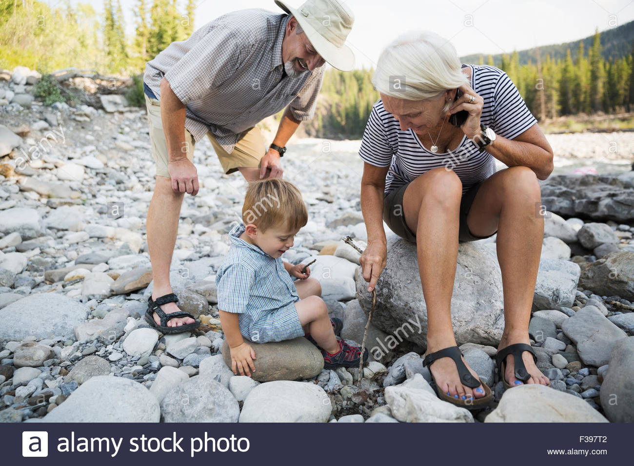 Grandparents and grandson playing in rocks Stock Photo